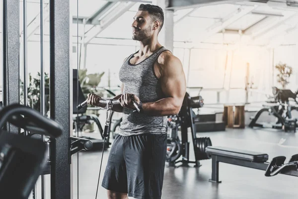 Hombre sonriente haciendo ejercicio con equipo —  Fotos de Stock