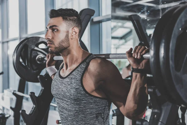 Serious bearded athlete pumping iron — Stock Photo, Image