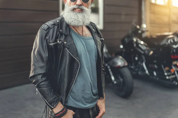 Fröhlich lächelnder älterer Mann in der Nähe von Motorrädern — Stockfoto