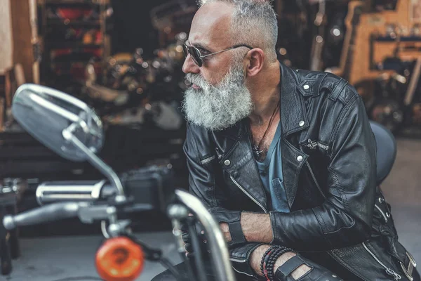 Stern old man ready for using motorbike — Stock Photo, Image