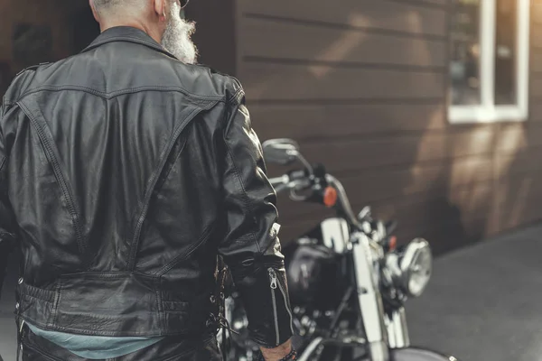 Зрілий чоловік стоїть біля мотоцикла — стокове фото