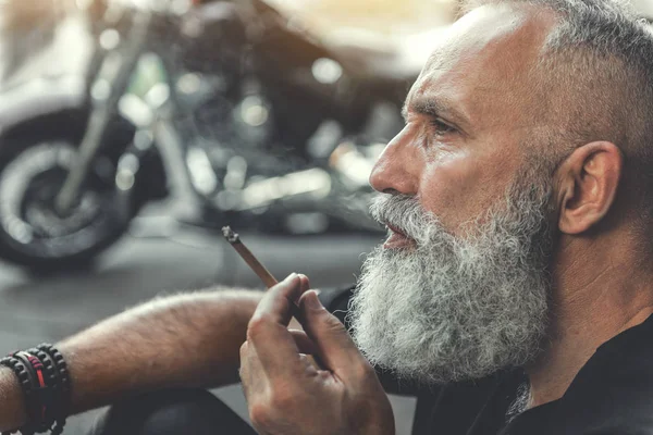 Viejo serio manteniendo el humo — Foto de Stock