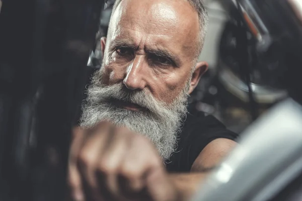 Vieil homme sérieux faisant la rénovation de vélo — Photo