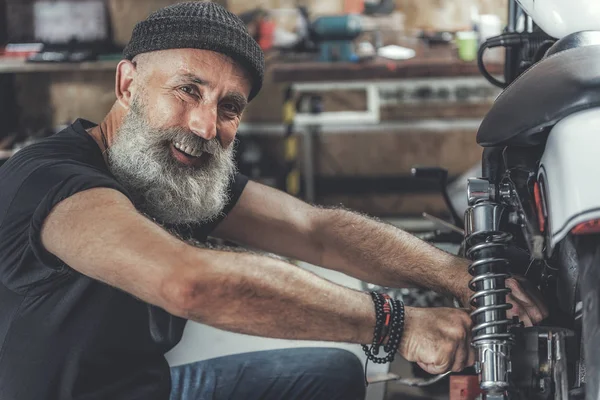 Alegre sorrindo ancião homem na oficina — Fotografia de Stock