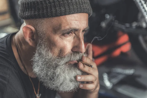 Serious aged man taking nicotine from cigarette — Stock Photo, Image