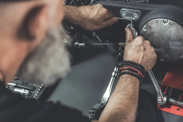 Volwassen bebaarde man doen renovatie van motor — Stockfoto