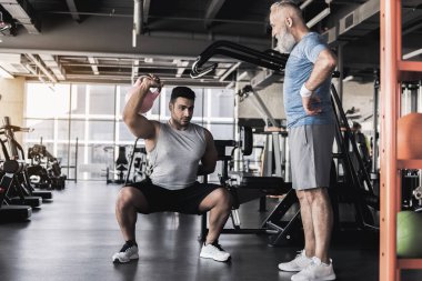 Eğitmen eski erkek, modern spor salonu ile çalışma