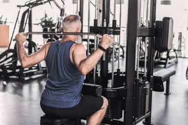 Konsantre kıdemli erkek modern bir spor salonu egzersizleri yapıyor