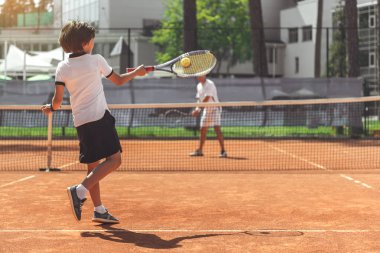 Erkek çocuk rakip Tenis oynarken