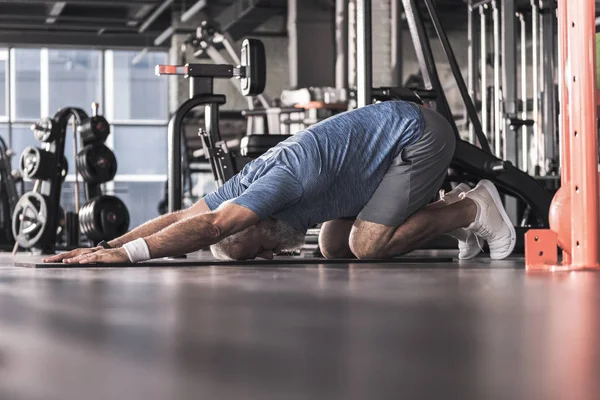 Şık kıdemli erkek fitness merkezinde zaman harcamaktadır