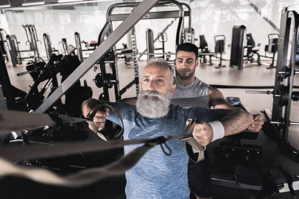 Olgun sporcu spor Merkezi'nde eğitmen ile egzersiz geçiriyor