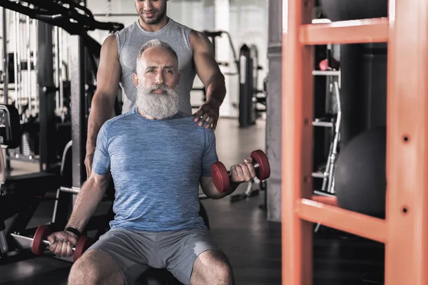 Şık kıdemli erkek spor Merkezi'nde eğitmen ile zaman geçirmekten — Stok fotoğraf