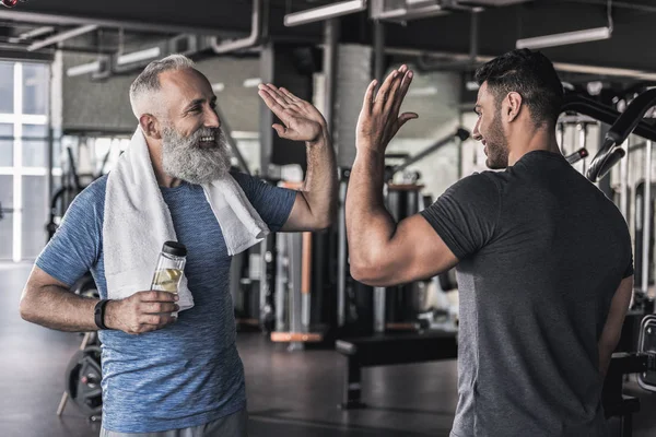 Neşeli erkekler birbirine modern spor salonunda konuşuyorsun — Stok fotoğraf