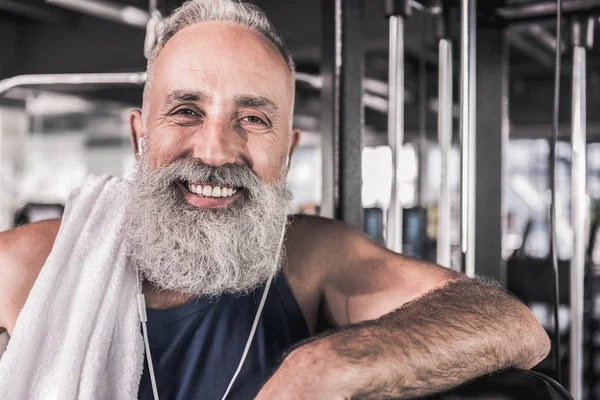 Pozitif kıdemli erkek spor merkezinde dururken gülümsüyor