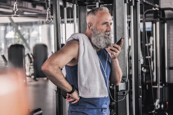 Spor salonunda cep telefonunda konuşmayı kendine güvenen kıdemli erkek — Stok fotoğraf