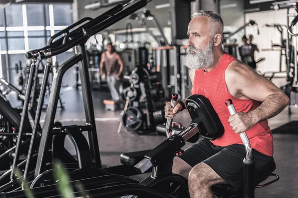 Hoş kıdemli erkek spor Merkezi'nde yoğun egzersiz geçiriyor — Stok fotoğraf