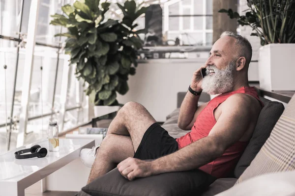Vrolijke oude man heeft aangename gesprek op smartphone — Stockfoto