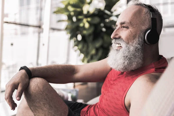 Neşeli emekli en sevdiğiniz şarkıları kanepede otururken keyif alıyor