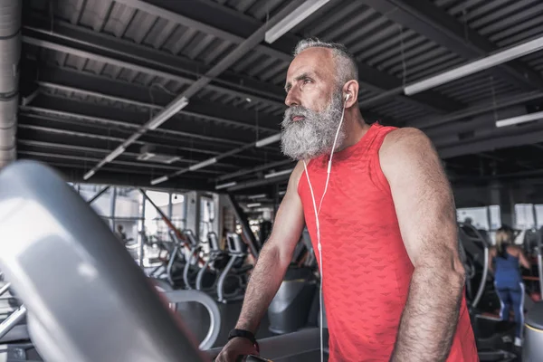 Sakallı şık erkek modern spor salonunda kardiyo yaparak