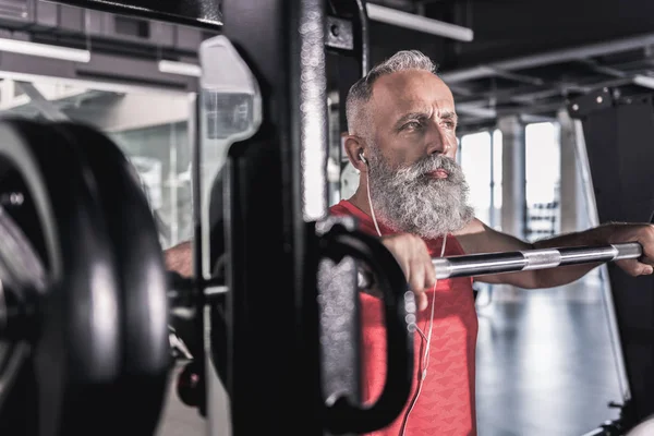Серйозний чоловік з бородою насолоджується тренуванням у спортивному центрі — стокове фото