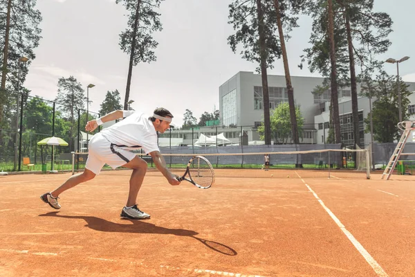 Entrenador concentrado jugando al tenis al aire libre —  Fotos de Stock