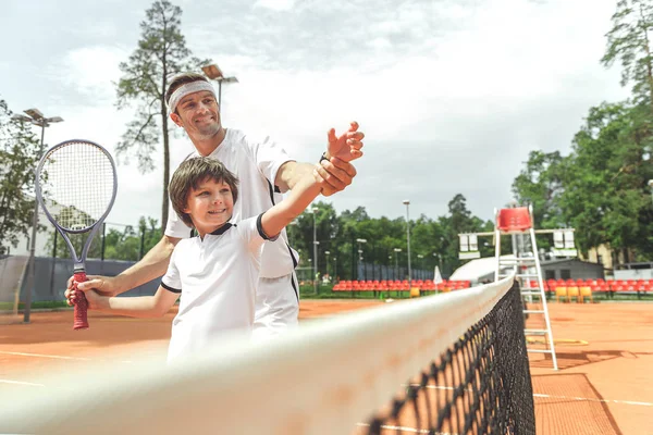 Χαρούμενη οικογένεια χαμογελώντας παίζοντας τένις — Φωτογραφία Αρχείου