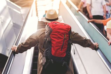 Havaalanında yürüyen merdiven üzerinde duran emekli