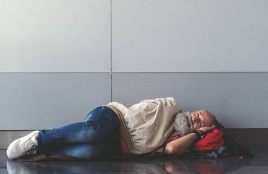 Mutlu gülümseyen yaşlı adam yerde yatıyor