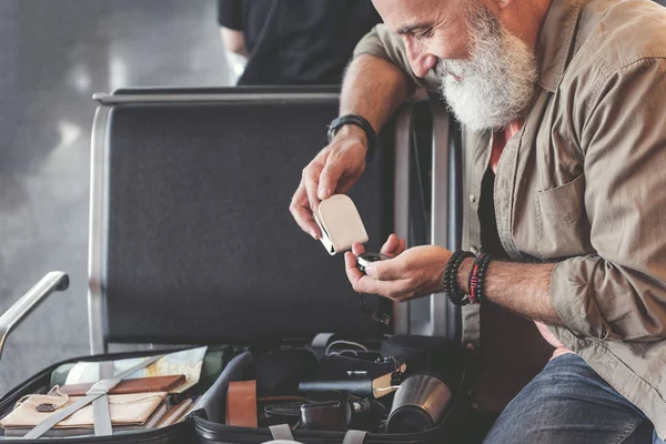 Alegre abuelo viendo en brújula en el aeropuerto — Foto de Stock