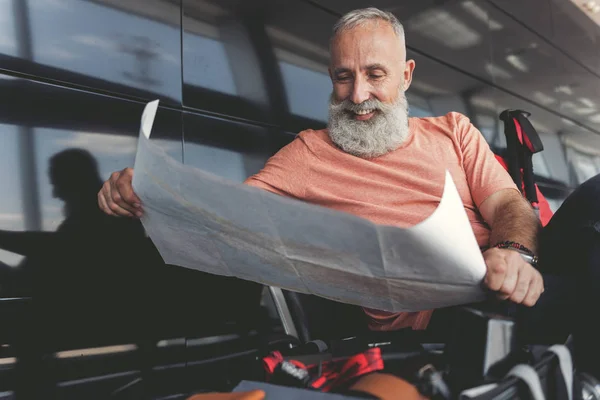 Alegre viejo sonriente pensando en la ruta — Foto de Stock