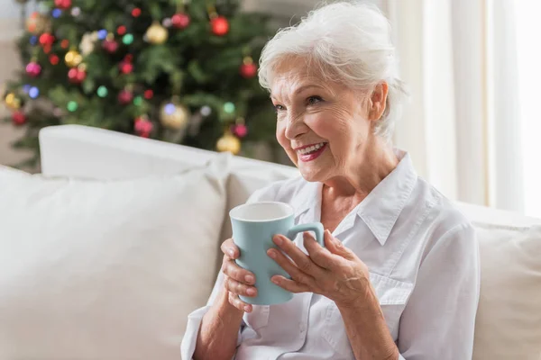 Señora de edad positiva es relajarse en el sofá — Foto de Stock