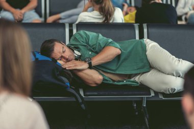 Yorgun adam kalkış alanı koltuk yatıyor