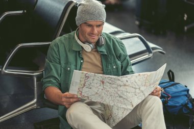 Neşeli yetişkin adam Havaalanı dinlenme odasında dinleniyor