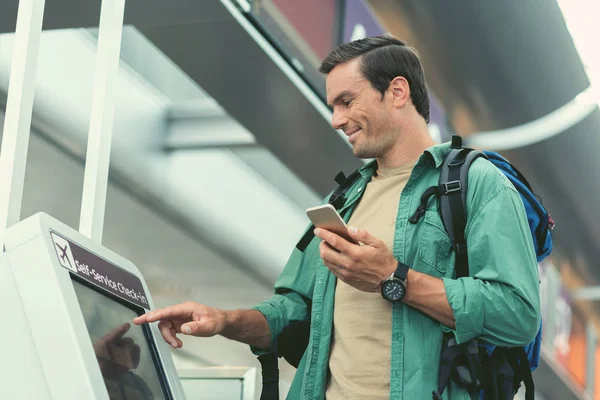 Neşeli Gezgin smartphone ile etkileşimli ekran dokunuyor