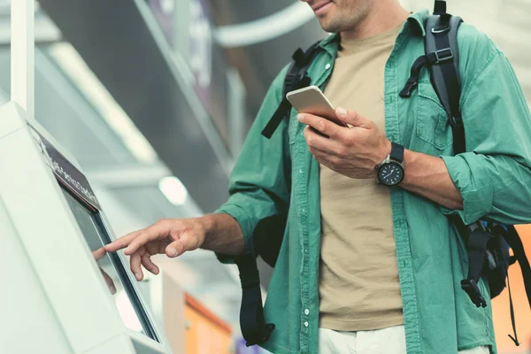 Homem agradável com telefone móvel está tocando exibição interativa — Fotografia de Stock