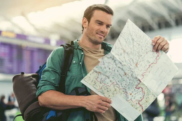 Neşeli genç adam havaalanında duruyor