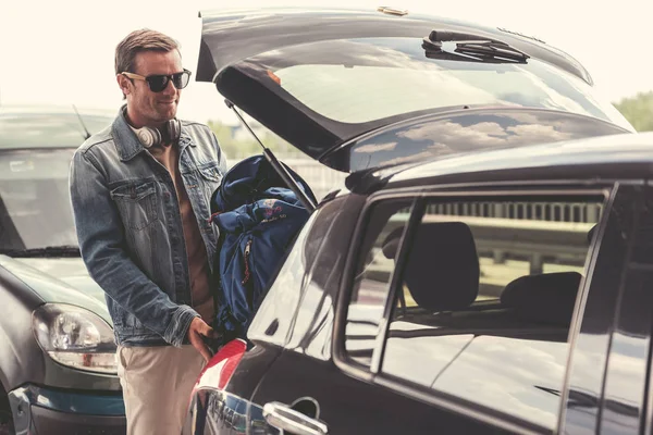 Pozitif yetişkin çantasını koyuyor