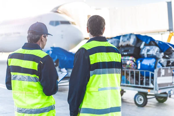 Arbeiter kontrollieren Gepäck auf Flugplatz — Stockfoto