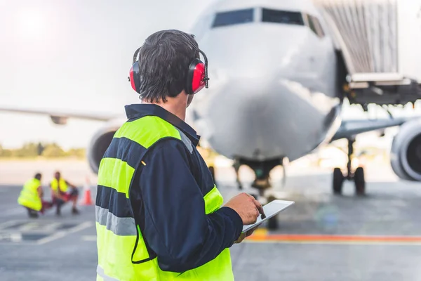 Lavoratori di sesso maschile che controllano aeromobili e scrivono informazioni — Foto Stock