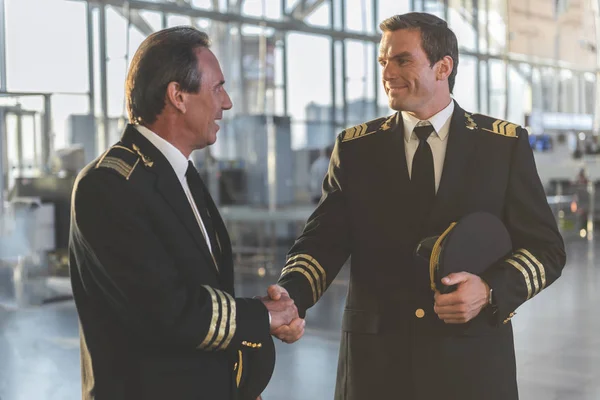 Strahlende Piloten mit verschränkten Armen auf Flugplatz — Stockfoto