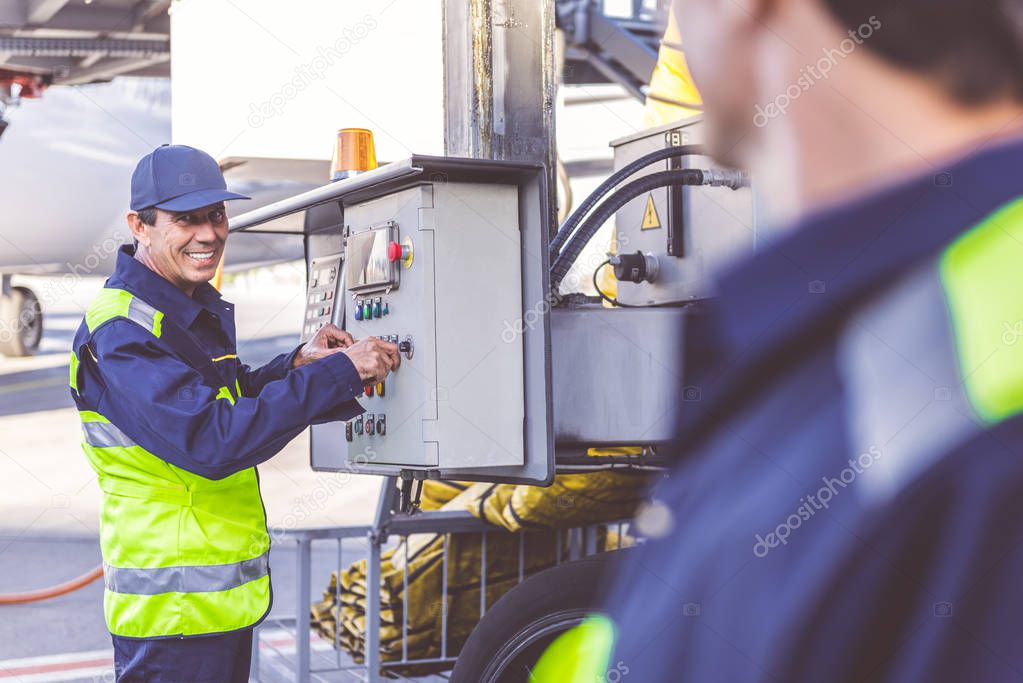 Cheerful worker controlling tool at airdrome