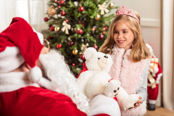 Cheerful girl receiving teddy bear as Christmas present — Stock Photo, Image