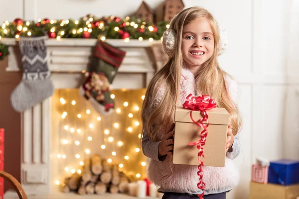 Excited female child keeping holiday gift — Stock Photo, Image