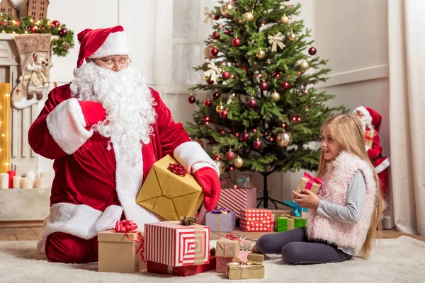Menina alegre recebendo presente de Natal de Santa — Fotografia de Stock