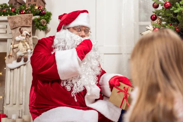 Mysterious Santa Claus laying presents under Christmas tree — Stock Photo, Image