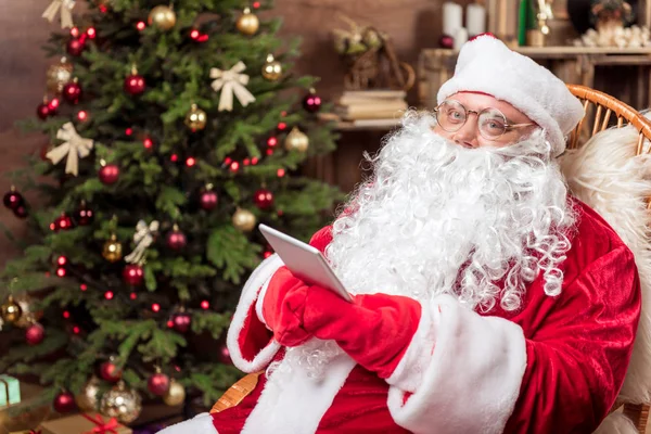 Neşeli Noel Baba holding tablet evde — Stok fotoğraf