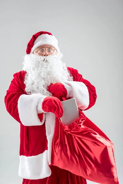 Förvånad gubbe i röd kostym förbereder närvarande på jul — Stockfoto
