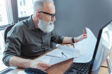 Ciddi yaşlı mühendis ofisinde çalışıyor