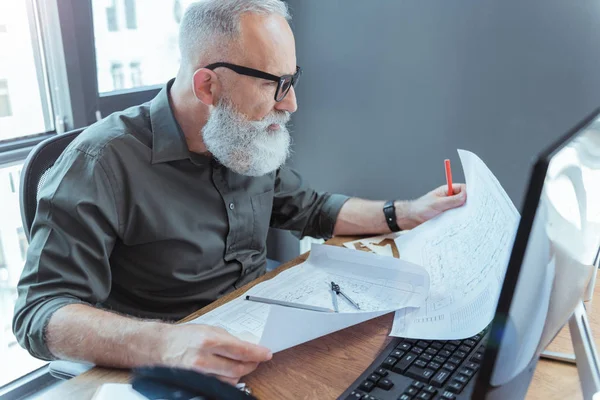 Ciddi yaşlı mühendis ofisinde çalışıyor