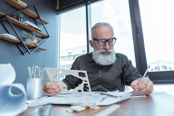Stylish mature engineer is laboring on his building plan — Stock Photo, Image